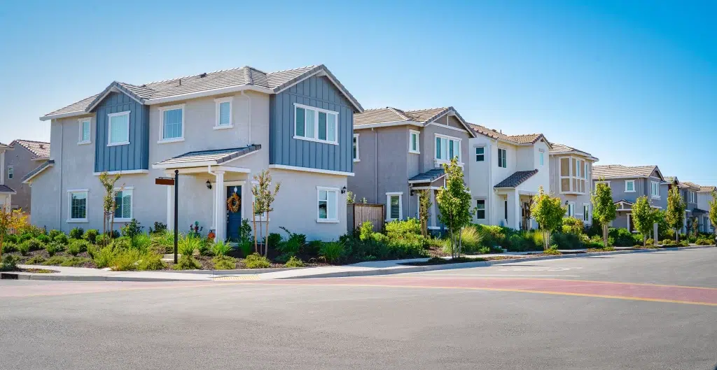 Modern suburban houses in california for sell with gardens on sunny day.