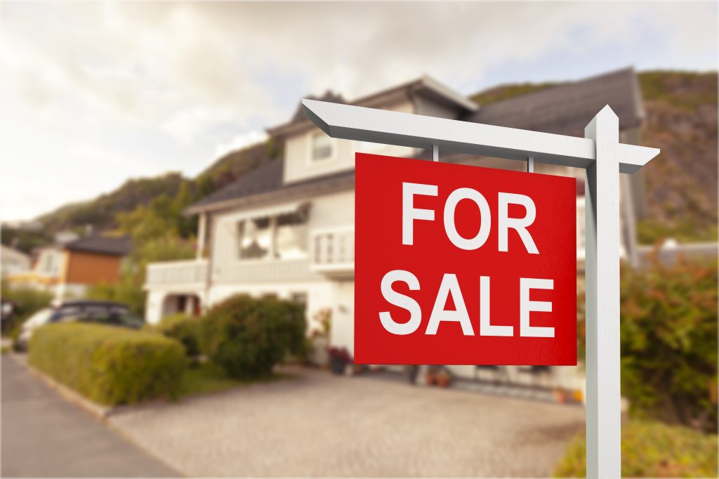 House for sale sign in front garden.