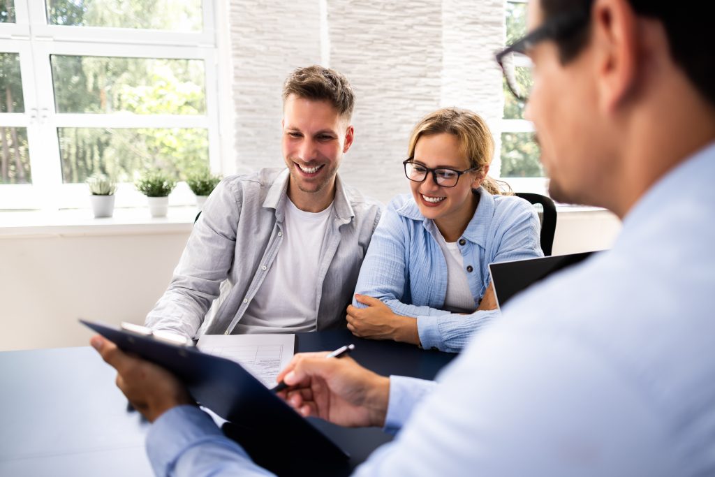 Couple meeting financial advisor in office.