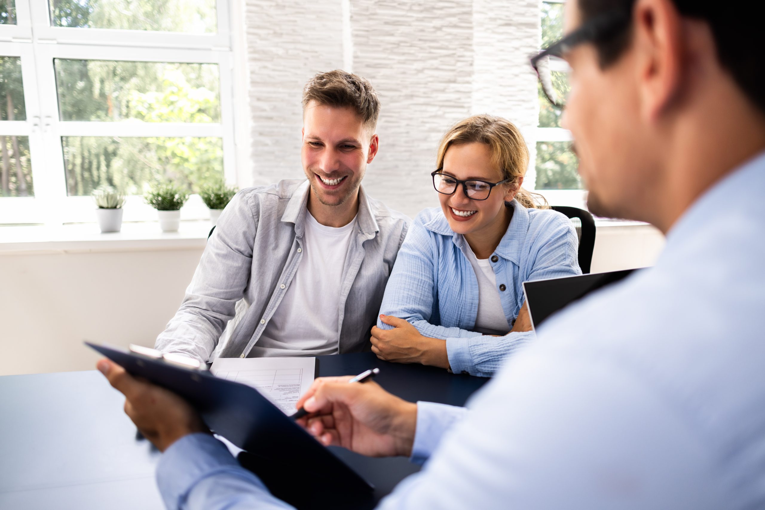 Couple meeting financial advisor in office.