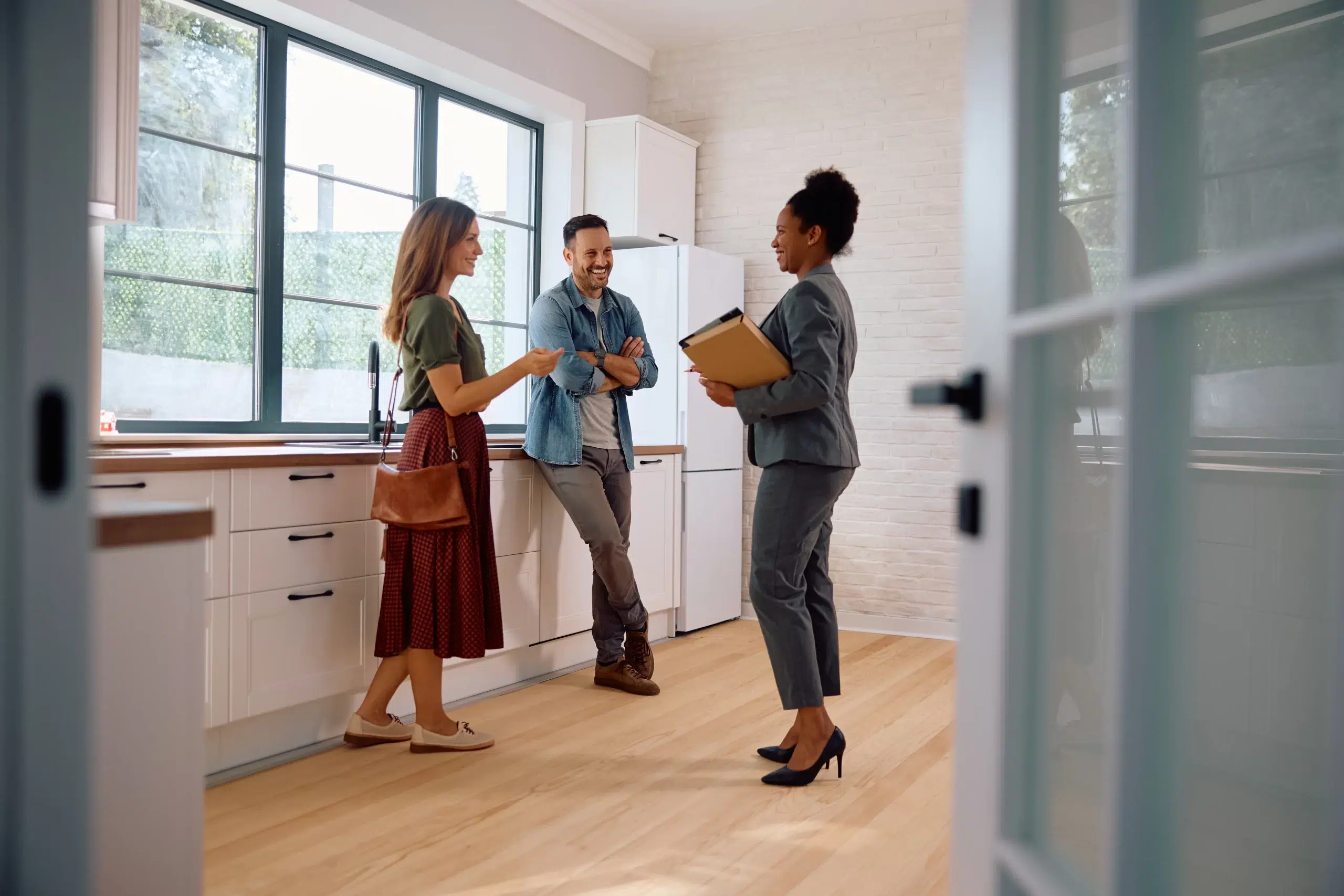 flat fee Real estate agents showing modern kitchen to clients.