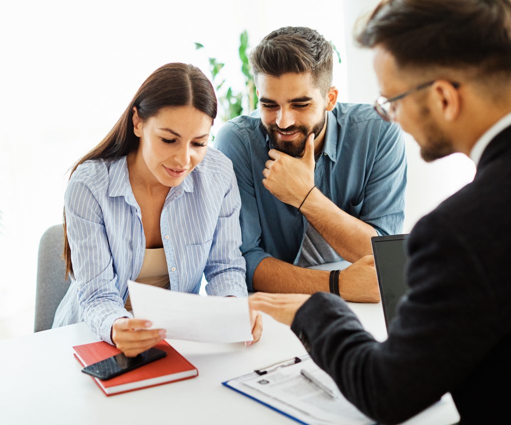 Couple discussing document with professional advisor.