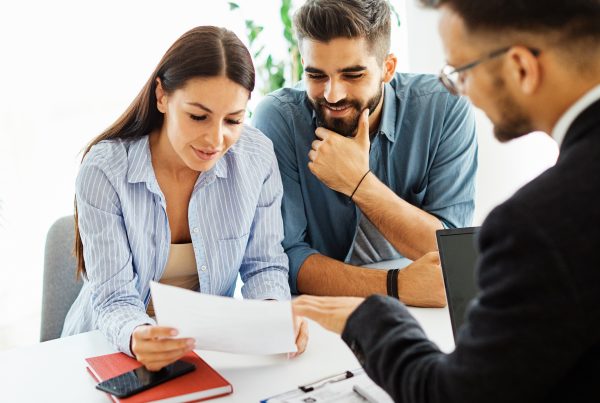 Couple discussing document with professional advisor.