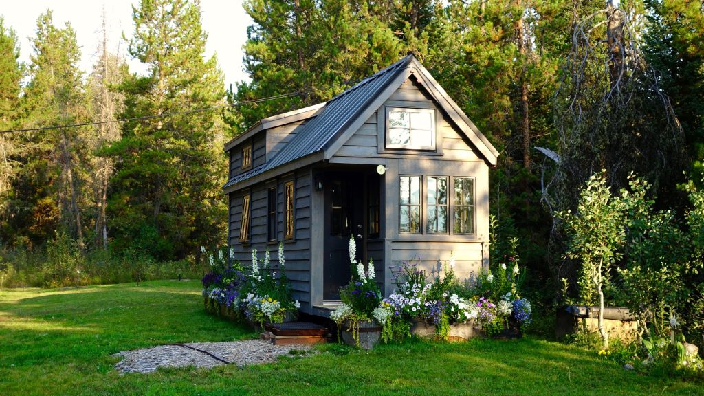 Tiny house with garden and forest backdrop